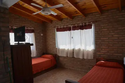 a bedroom with two beds and a ceiling fan at Cabañas MACONDO in Villa Ciudad Parque