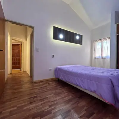 a bedroom with a purple bed in a room at Amplia casa a solo unos metros del centro - RentVGB in Villa General Belgrano