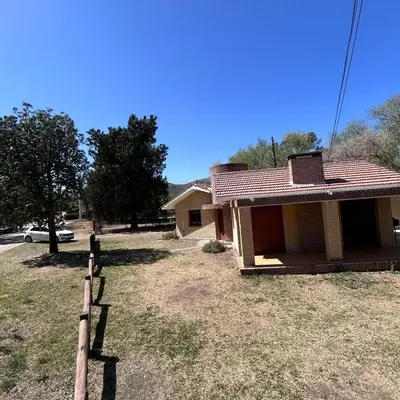 a small house with a fence in front of it at Amplia casa a solo unos metros del centro - RentVGB in Villa General Belgrano