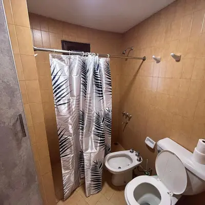 a bathroom with a toilet and a shower curtain at Amplia casa a solo unos metros del centro - RentVGB in Villa General Belgrano