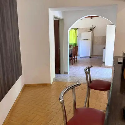 a room with two chairs and a hallway with a refrigerator at Amplia casa a solo unos metros del centro - RentVGB in Villa General Belgrano