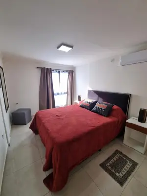 a bedroom with a red bed and a window at Depto triplex frente el lago in Villa Carlos Paz