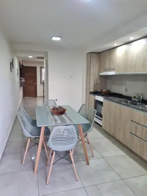 a dining room with a table and chairs in a kitchen at Depto triplex frente el lago in Villa Carlos Paz