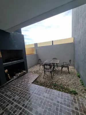 a patio with a table and chairs and a fireplace at Depto triplex frente el lago in Villa Carlos Paz