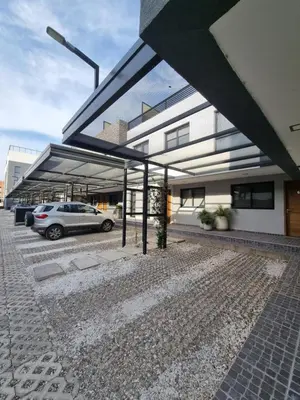 a car parked in a parking lot in front of a building at Depto triplex frente el lago in Villa Carlos Paz