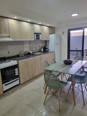 a kitchen with a table and chairs in a room at Depto triplex frente el lago in Villa Carlos Paz