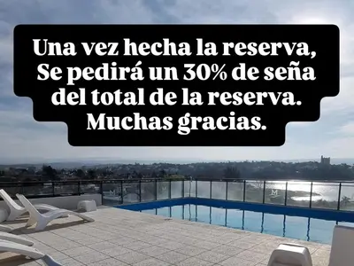a sign above a swimming pool on top of a building at Depto triplex frente el lago in Villa Carlos Paz