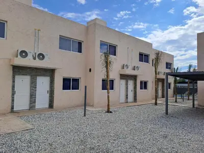 a building with two palm trees in front of it at Baumhaus in Villa Anizacate