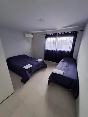 two beds in a small room with a window at Baumhaus in Villa Anizacate