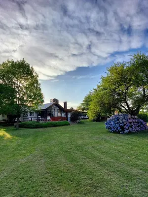 a yard with a house and flowers in the grass at Casa con vista al lago en Potrero de Garay in La Estancia