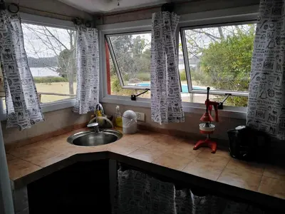 a kitchen with a sink and two windows at Casa con vista al lago en Potrero de Garay in La Estancia