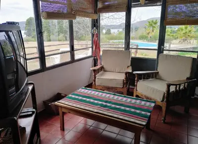 a living room with two chairs and a couch and a tv at Casa con vista al lago en Potrero de Garay in La Estancia
