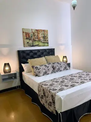 a bedroom with a large bed and two lamps at Departamento de Santa Rosa in Cordoba