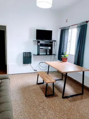 a living room with a coffee table and a tv at Departamento de Santa Rosa in Cordoba