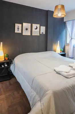 a bedroom with a large white bed with pictures on the wall at Trejo 351 in Cordoba