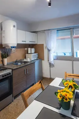 a kitchen with a table with flowers on it at Trejo 351 in Cordoba