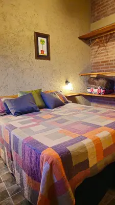 a bedroom with a bed with a colorful blanket at Departamentos Atardecer Serrano in Arroyo de Los Patos