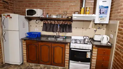 a small kitchen with a refrigerator and a stove at Departamentos Atardecer Serrano in Arroyo de Los Patos