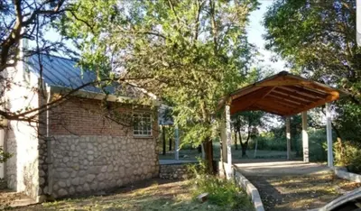 a brick building with a pavilion in a park at Cabaña La Lechuza en LAS RABONAS in Mina Clavero