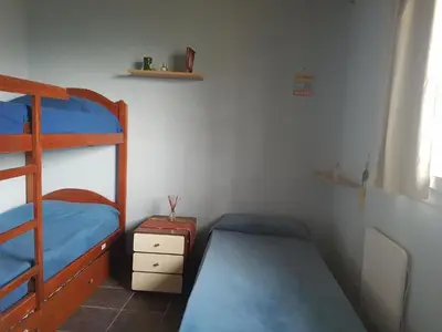 a bedroom with two bunk beds and a shelf at Cabaña La Lechuza en LAS RABONAS in Mina Clavero