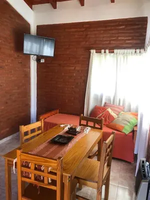 a dining room with a table and a couch at Cabañas Ipachi Naguan in Villa Rumipal