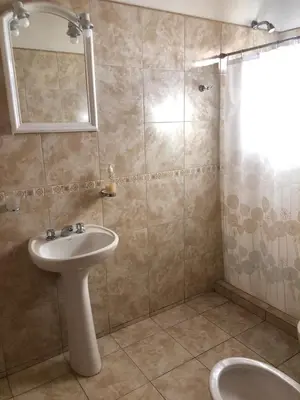 a bathroom with a sink and a mirror and a shower at Cabañas Ipachi Naguan in Villa Rumipal
