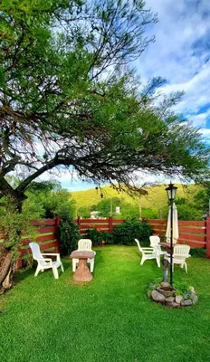 a group of chairs and a table and a tree at Cabañas Ipachi Naguan in Villa Rumipal