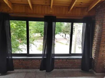 a window with black curtains on a brick wall at AMABLEs in Salsacate