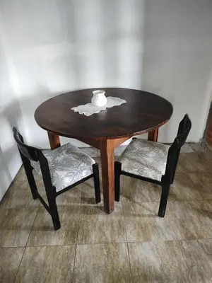 a wooden table with two chairs and a cup on top at AMABLEs in Salsacate