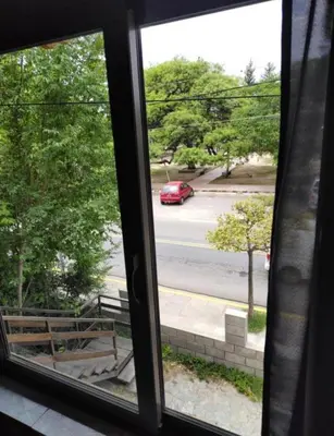 a window view of a red car driving down a street at AMABLEs in Salsacate