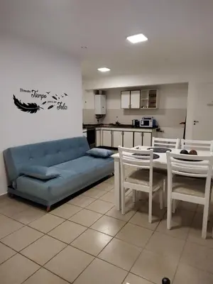 a living room with a blue couch and a table and chairs at Dpto Nuevocentro Shopping CON ESTACIONAMIENTO GRATUITO in Cordoba