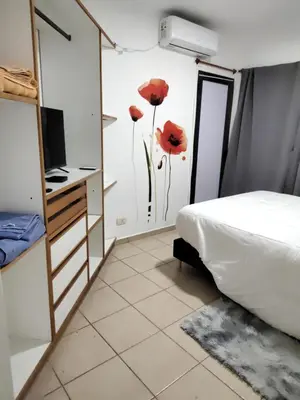 a bedroom with red poppies painted on the wall at Dpto Nuevocentro Shopping CON ESTACIONAMIENTO GRATUITO in Cordoba