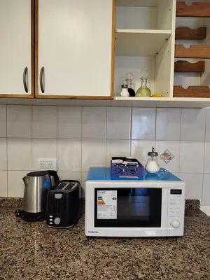 a microwave sitting on a counter in a kitchen at Dpto Nuevocentro Shopping CON ESTACIONAMIENTO GRATUITO in Cordoba