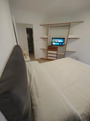 a bedroom with a bed and a flat screen tv at Dpto Nuevocentro Shopping CON ESTACIONAMIENTO GRATUITO in Cordoba