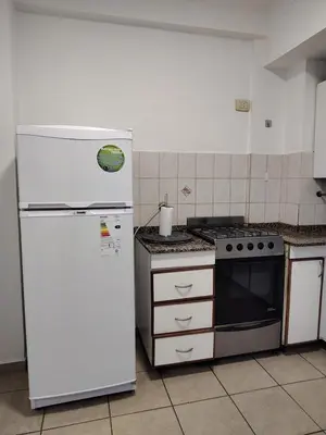 a kitchen with a white refrigerator and a stove at Dpto Nuevocentro Shopping CON ESTACIONAMIENTO GRATUITO in Cordoba