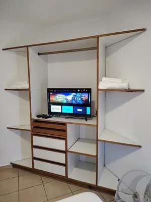 a shelf with a tv and a computer on it at Dpto Nuevocentro Shopping CON ESTACIONAMIENTO GRATUITO in Cordoba