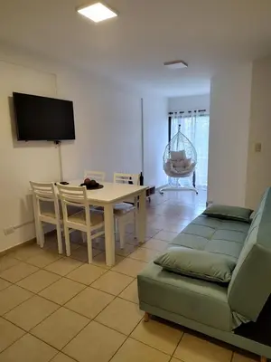 a living room with a table and a couch at Dpto Nuevocentro Shopping CON ESTACIONAMIENTO GRATUITO in Cordoba