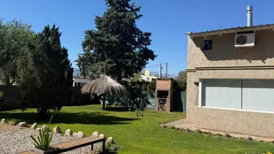 a backyard of a house with a grass yard at Duplex del Bosque - Solo Parejas in Mina Clavero
