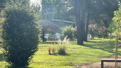 a garden with a table and chairs in the grass at Duplex del Bosque - Solo Parejas in Mina Clavero