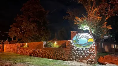 a stone fence with a sign on it at night at Duplex del Bosque - Solo Parejas in Mina Clavero