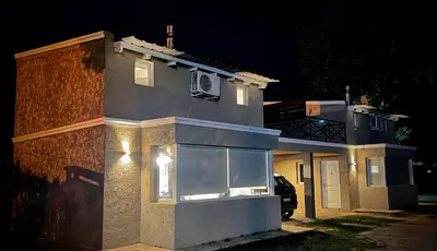 a house with a window on the side of it at night at Duplex del Bosque - Solo Parejas in Mina Clavero