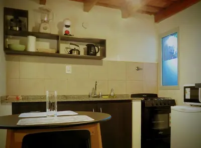 a kitchen with a table with a glass on it at Duplex del Bosque - Solo Parejas in Mina Clavero