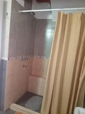 a shower with a shower curtain in a bathroom at Duplex del Bosque - Solo Parejas in Mina Clavero