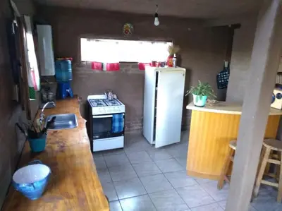 a kitchen with a white refrigerator and a stove at Cabaña El Colibri en Villa Amancay in Villa Amancay