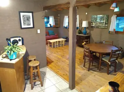 a kitchen and living room with a table and chairs at Cabaña El Colibri en Villa Amancay in Villa Amancay