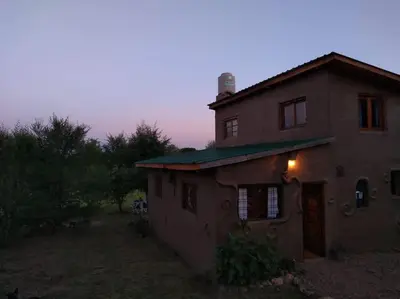 a house with a light on the side of it at Cabaña El Colibri en Villa Amancay in Villa Amancay