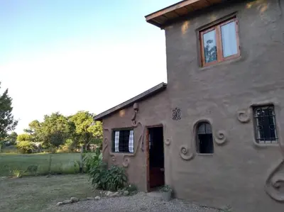 a stone house with a window and a door at Cabaña El Colibri en Villa Amancay in Villa Amancay