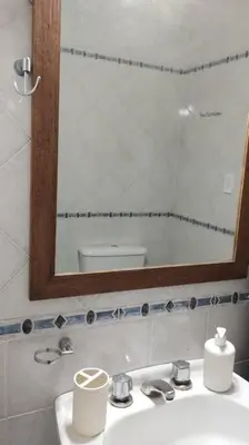 a bathroom with a sink with a mirror and a toilet at Spacious bright apartment with garage in Cordoba in Cordoba