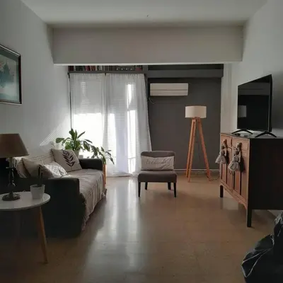 a living room with a couch and a tv at Spacious bright apartment with garage in Cordoba in Cordoba