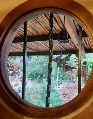 a round window with a view of a garden at Piedramadre hermosa cabaña a metros del río hasta 4 huéspedes in Cordoba